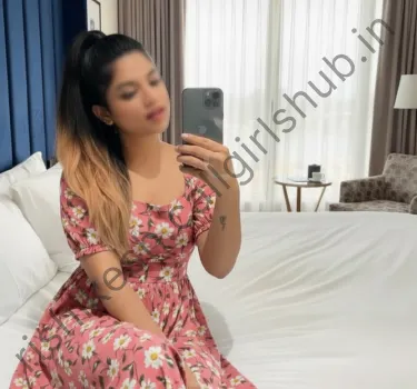 Niya,Independent high profile call girl in rishikesh wearing flower printed gown sitting on bed and taking selfie