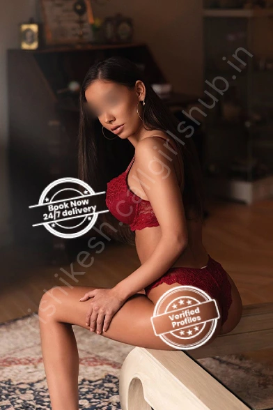 Independent Call Girl in Rishikesh Reshma sitting on bed wearing red dress and showing book now and verified profiles